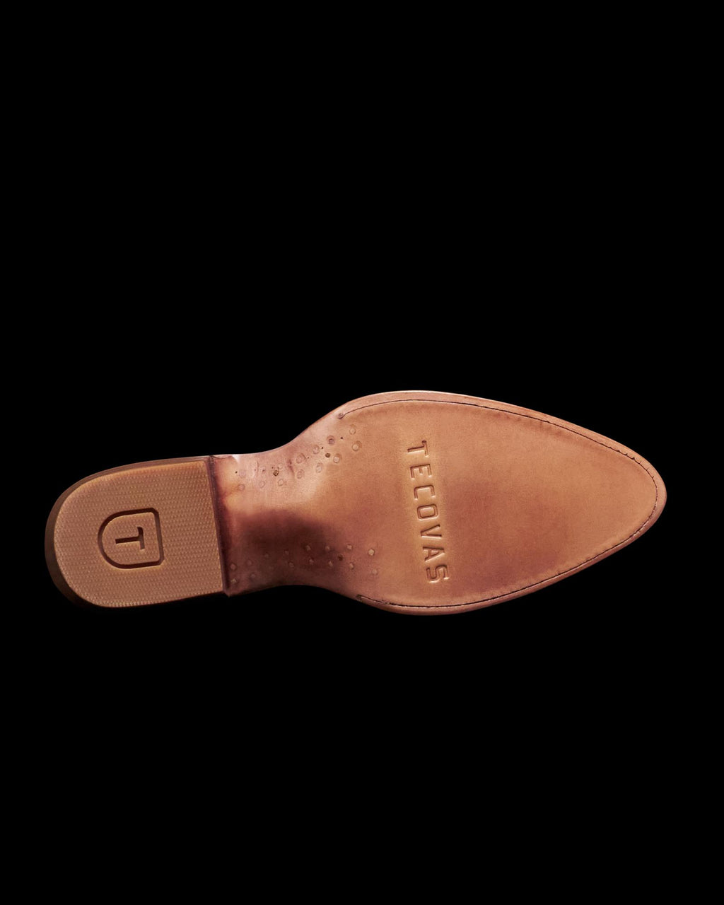 Bottom view of a white cowboy boot with a tan leather sole featuring the brand name "Tecovas" and a rubber heel with a "T" logo.