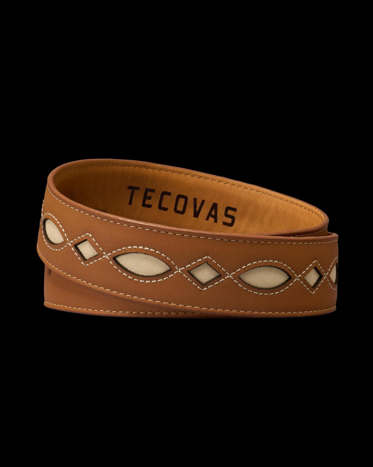 A brown leather belt with cream inlays and white stitching, featuring the brand name “Tecovas” on the inside.