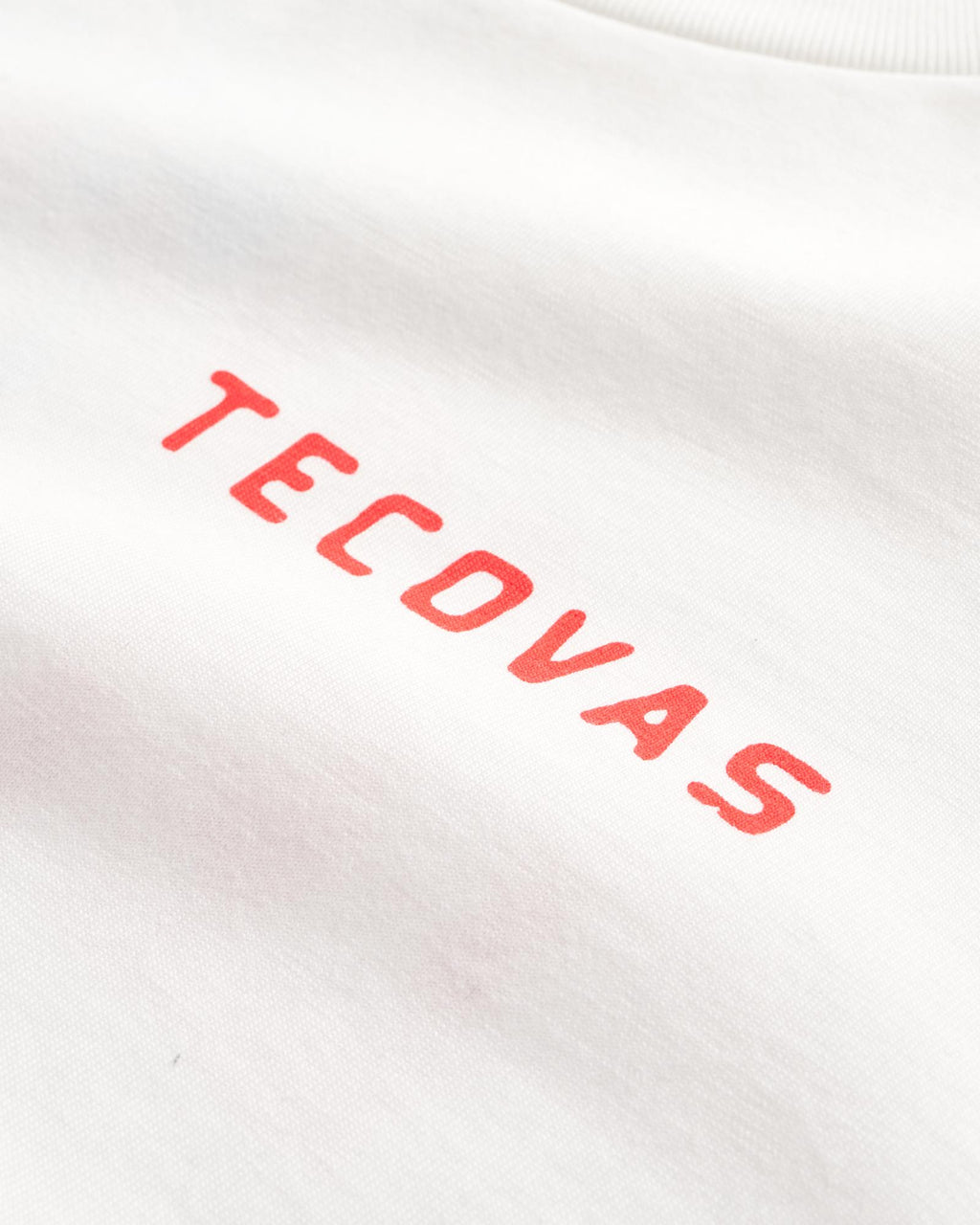 White fabric with the word "TECOVAS" printed in red, capital letters in a simple font.
