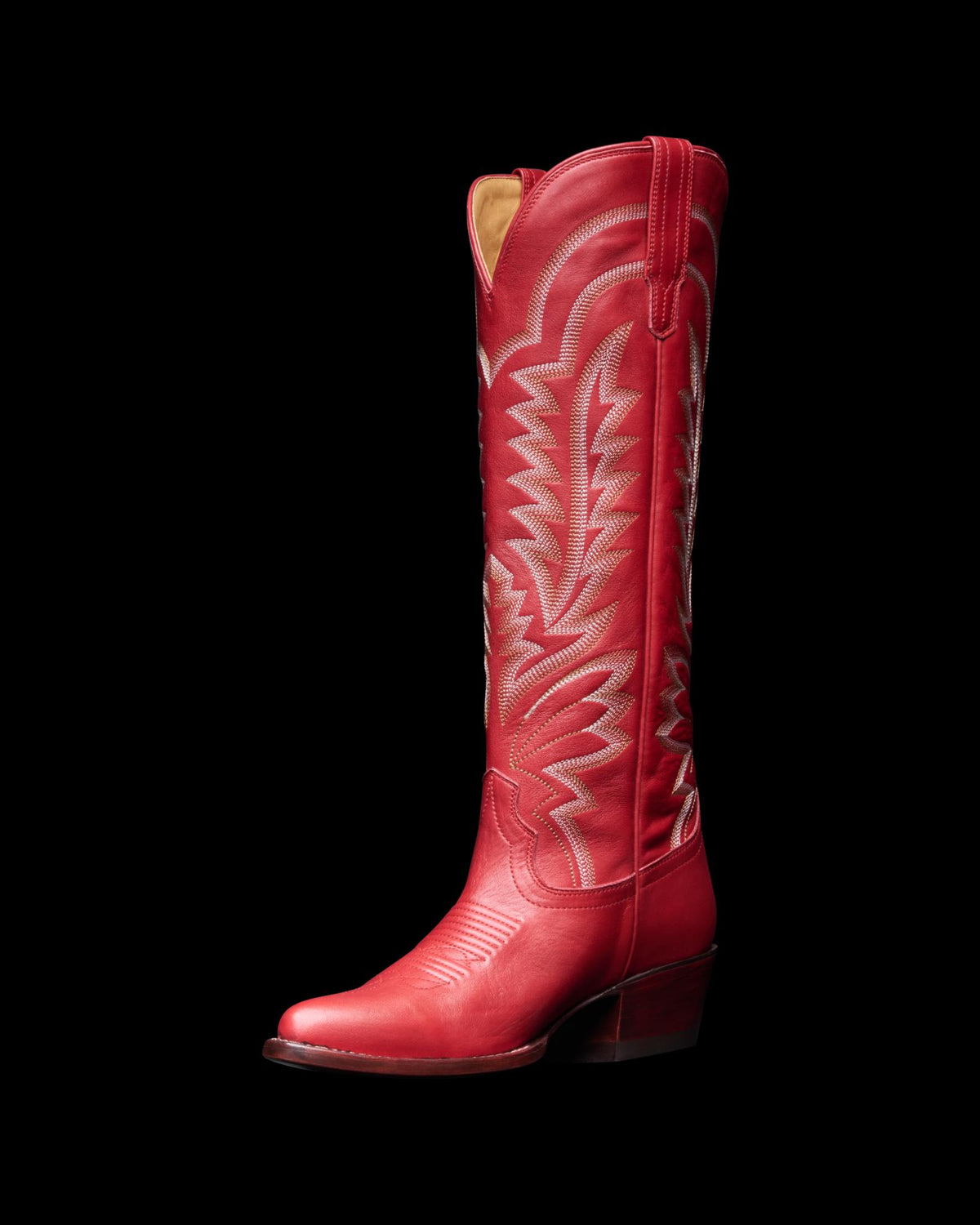 The Abby Wide Calf in Crimson Cowhide. A tall crimson cowhide leather cowboy boot with decorative white stitching, a pointed toe, and a low angled heel is shown against a plain white background.
