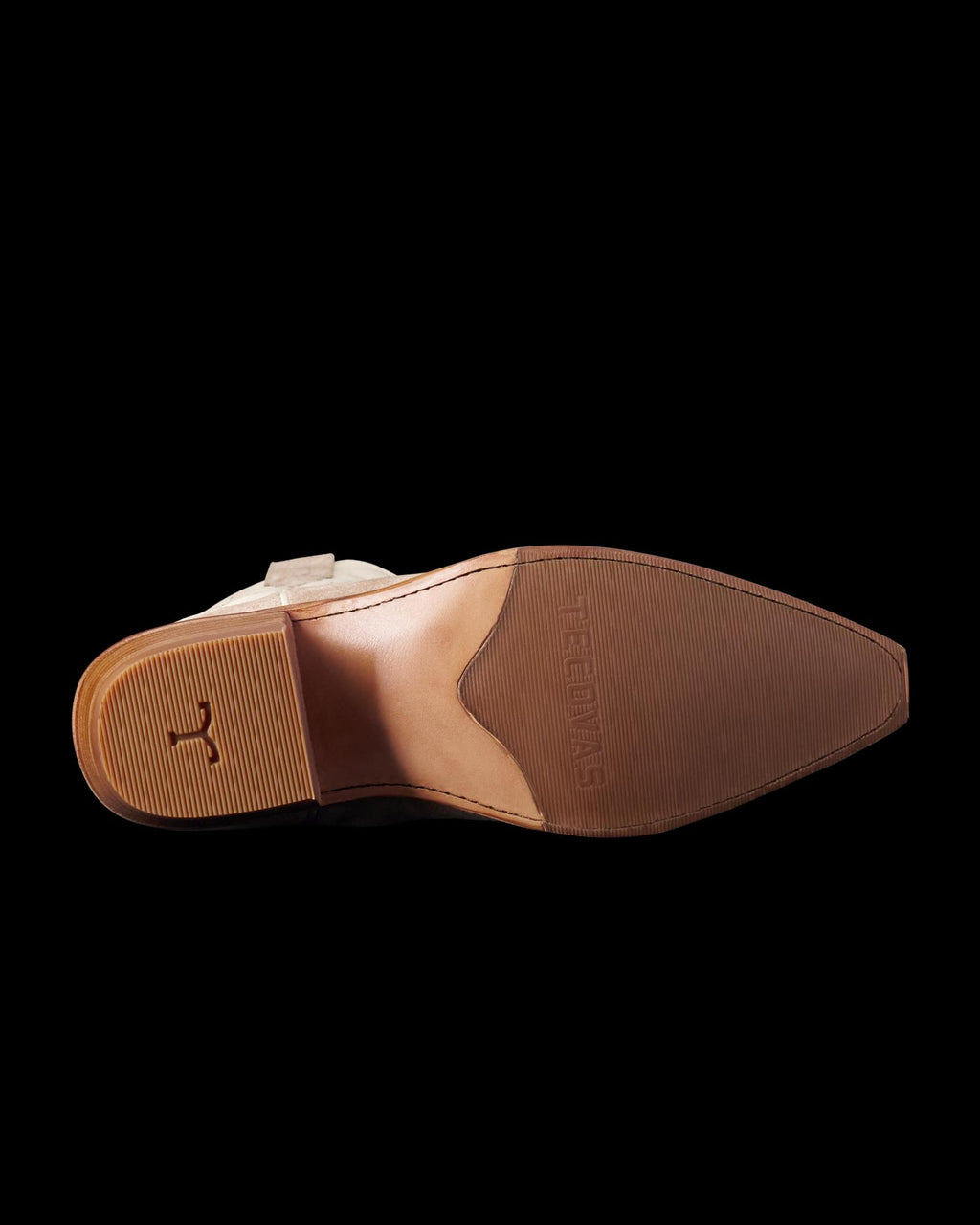 The image shows the sole of a brown leather shoe with a small heel and a textured grip pattern.