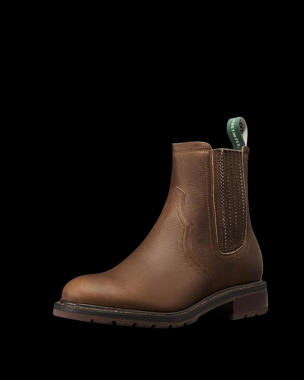 Brown leather Chelsea boot crafted from premium cowhide, featuring elastic side panels, a green pull tab, and a low stacked heel—The Chelsea Cowhide is photographed on a white background, bringing refined cafe style to any look.