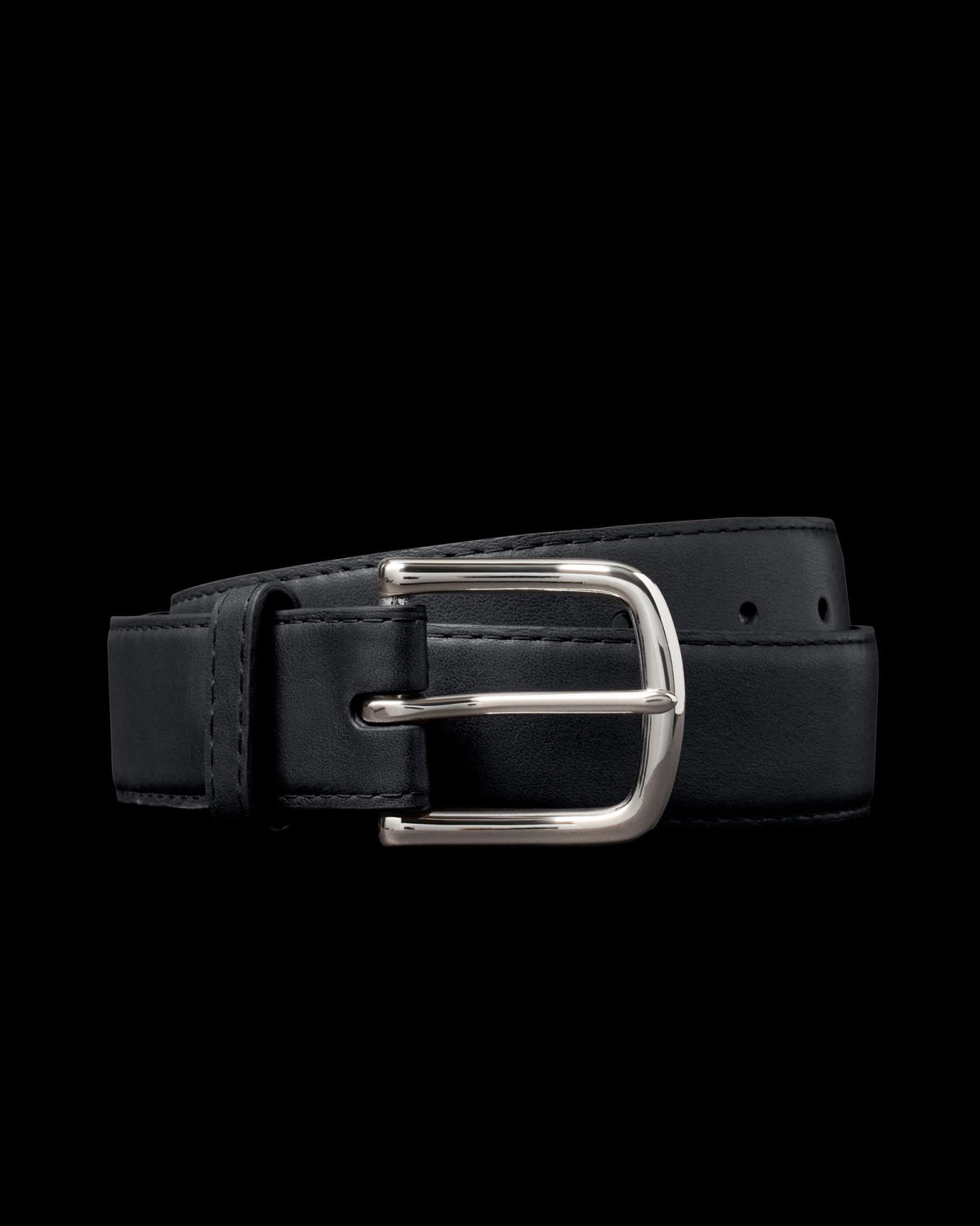 A black leather belt with a shiny silver buckle, coiled neatly against a plain black background.