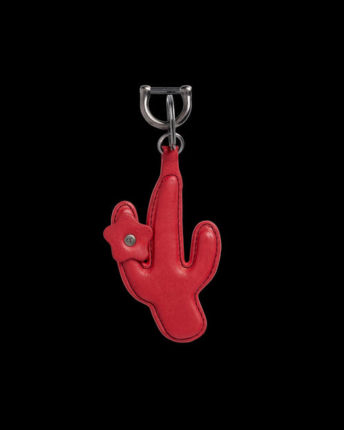 A red cactus-shaped leather keychain with a small flower detail, attached to a silver metal clasp.