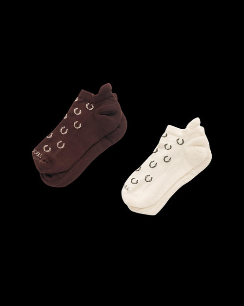 Two pairs of ankle socks, one brown and one white, each with a repeating crescent pattern, displayed on a plain white background.