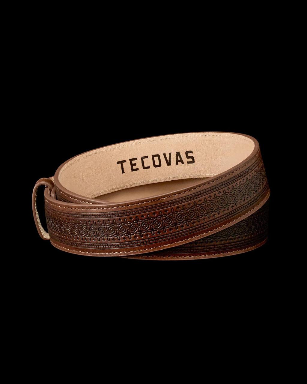 A brown leather belt with an embossed pattern and the word "Tecovas" printed on the inside.
