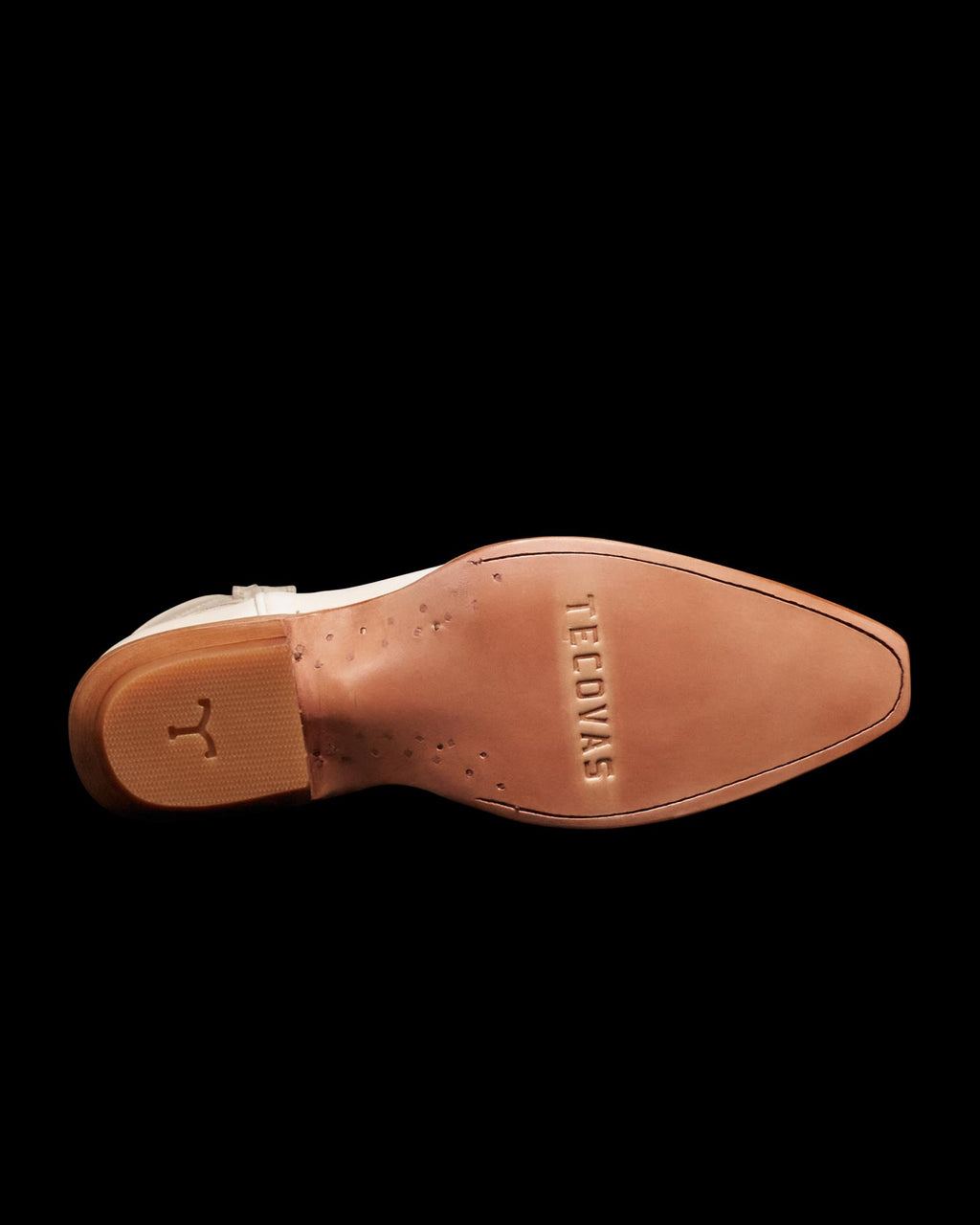 The image shows the sole of a cowboy boot with the brand name "Tecovas" engraved on the brown leather.
