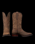 The Tess in Cafe Goat. A pair of brown leather cowboy boots with decorative stitching, inspired by The Tess Goat, one boot standing upright and the other displaying the front view.