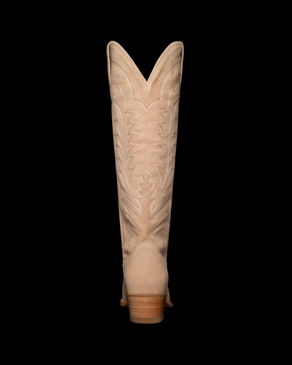 Back view of a beige cowboy boot with decorative stitching on the shaft, against a black background.