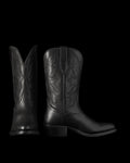 The Britt in Midnight Cowhide. Two black leather cowboy boots crafted from midnight cowhide with decorative stitching are shown; one boot faces forward, while the other is viewed from the side.