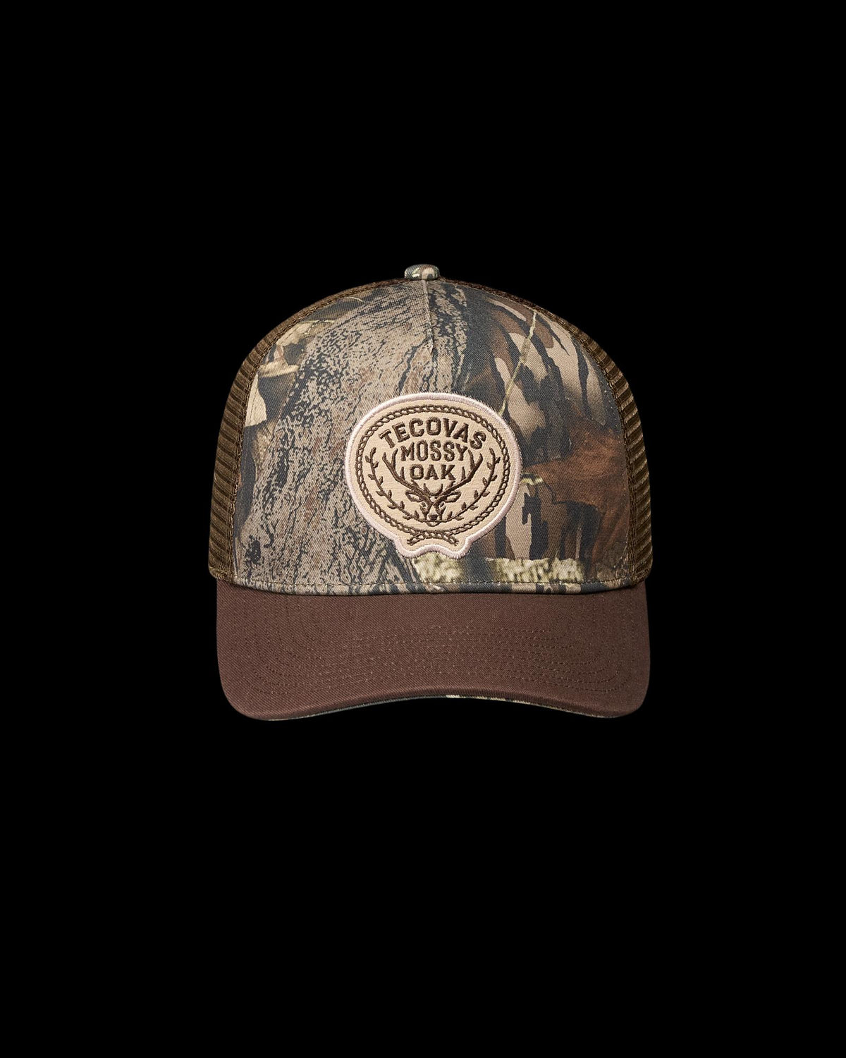 A camouflage-patterned trucker hat with a mesh back and a front patch that reads “Tecovas Mossy Oak.”.