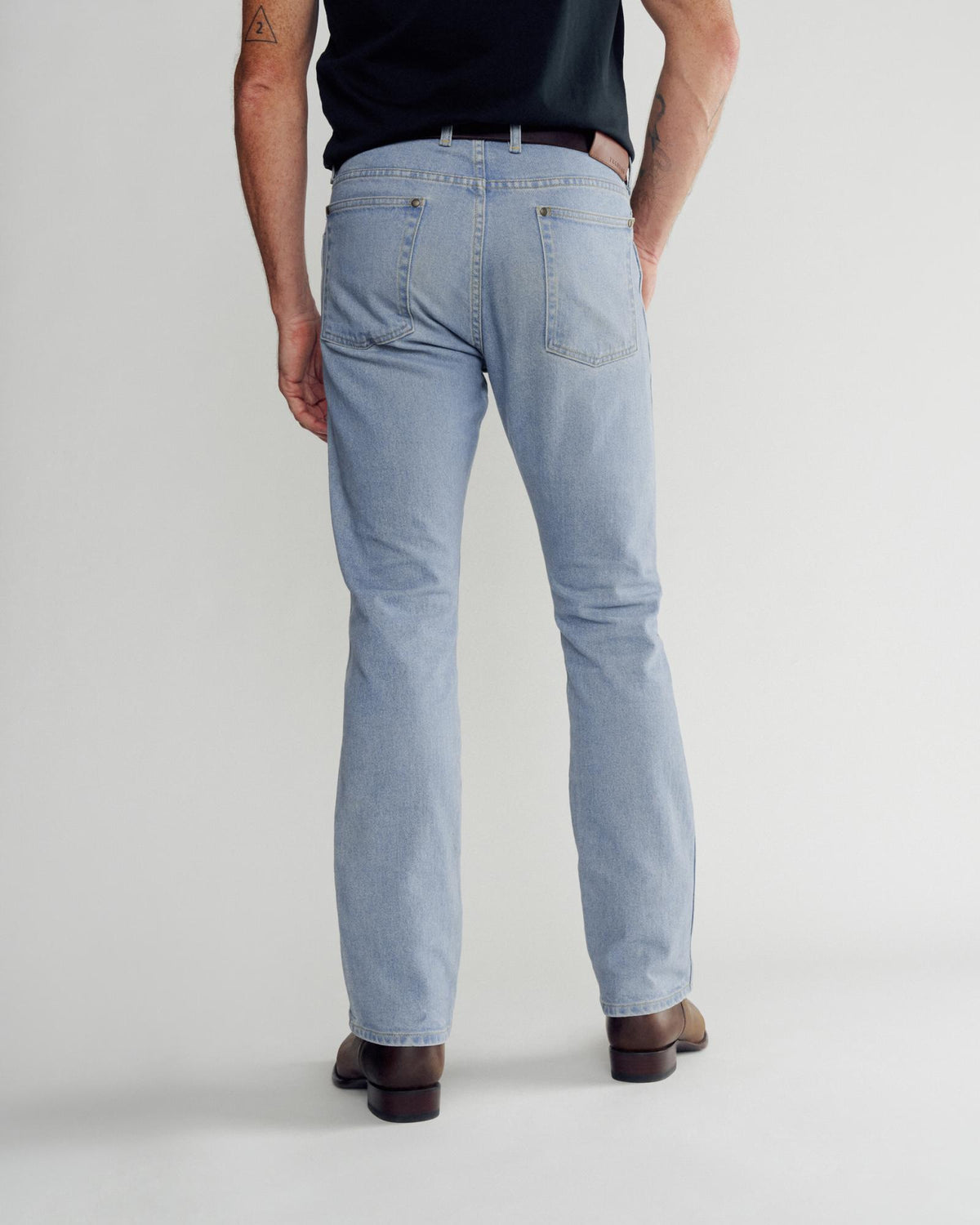 Back view of Men's Slim Straight Heritage Denim - Light Blue on model