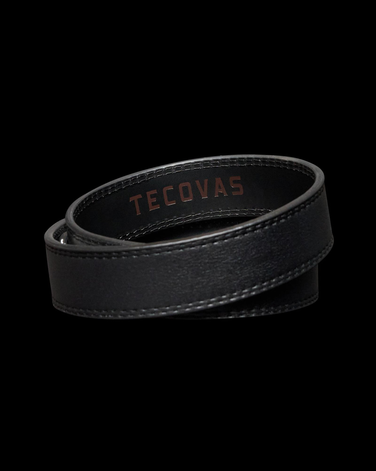 Coiled black leather strap with visible stitching and the word "Tecovas" embossed in brown.