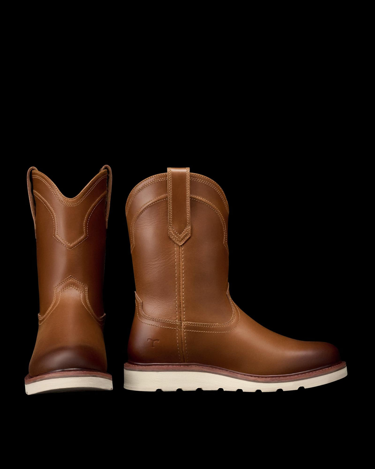 The Knox in Wheat Cowhide. A pair of The Knox Cowhide brown leather pull-on boots with white soles, one boot facing forward and the other angled to show the side profile.