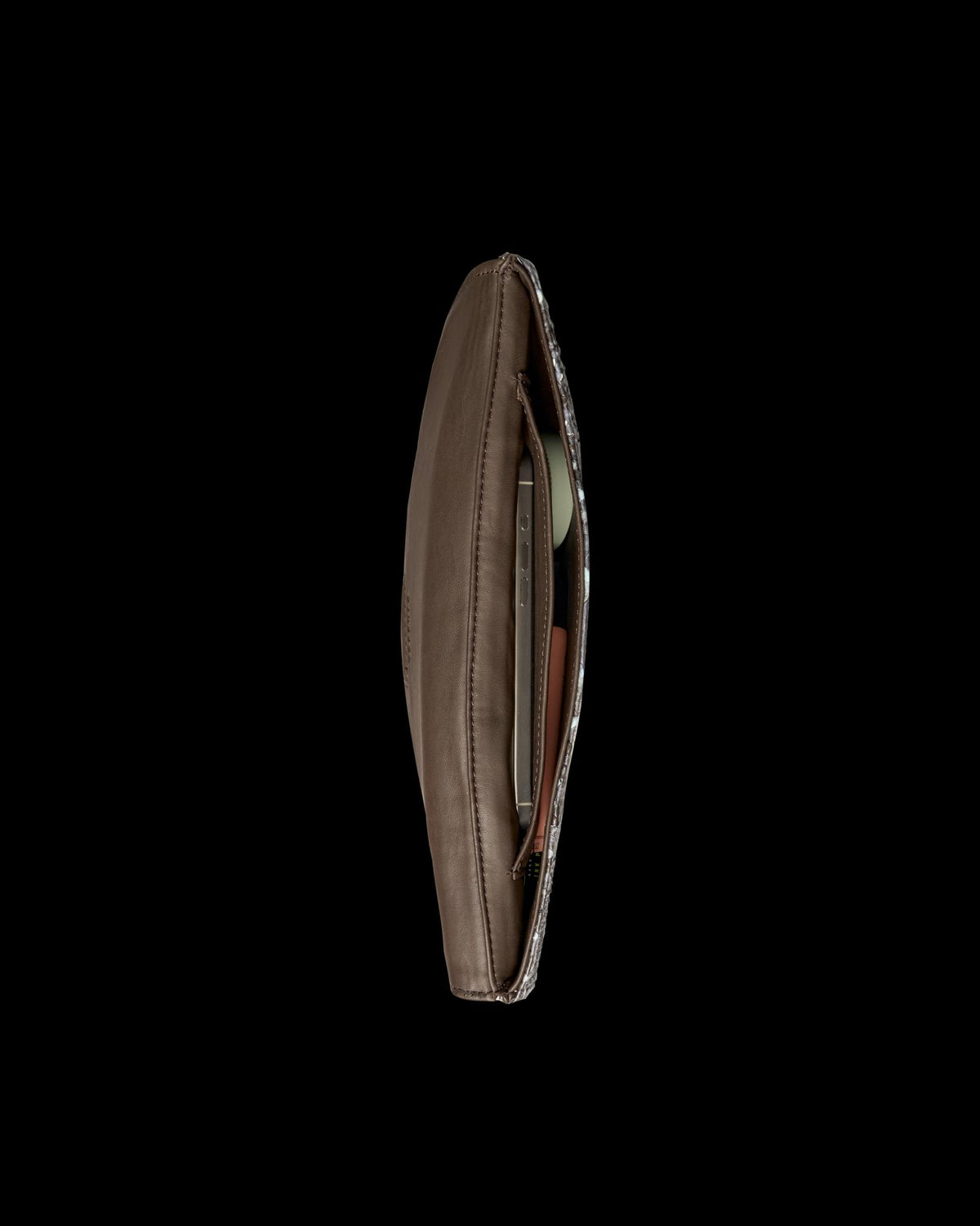 Top-down view of an open dark brown leather clutch containing a smartphone and a small compact.