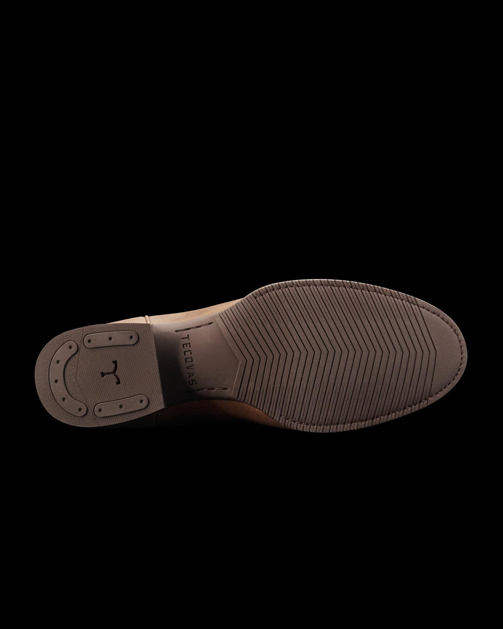 The Glen in Khaki Cowhide. The image shows the brown sole of a dress shoe crafted from premium cowhide, with textured grip patterns and the brand name "Tecovas" engraved in the center.