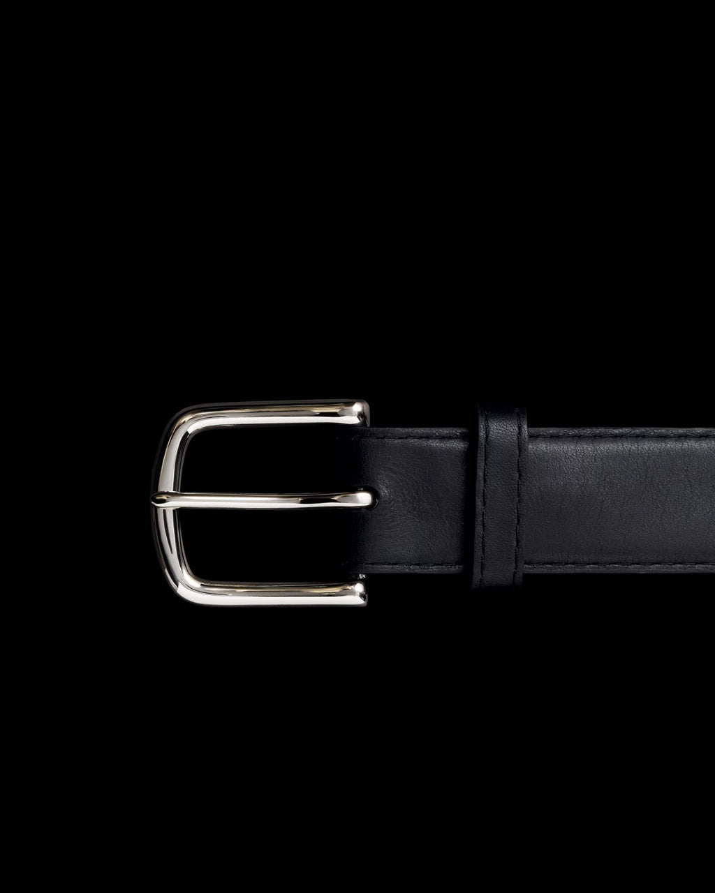 Black leather belt with a silver buckle against a black background.