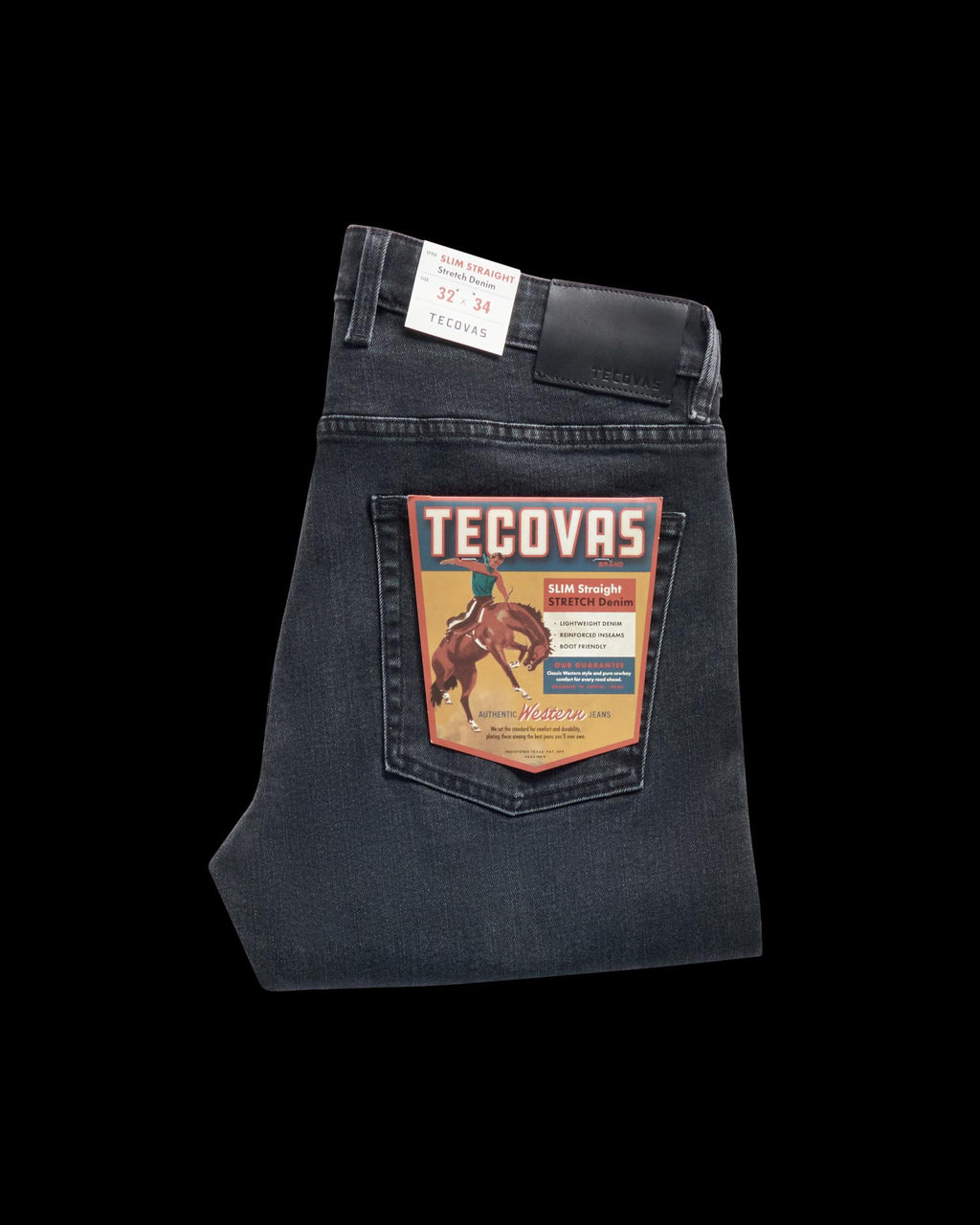 Folded pair of dark wash Tecovas jeans with a retail label featuring a rider on a horse, displayed on the back pocket.