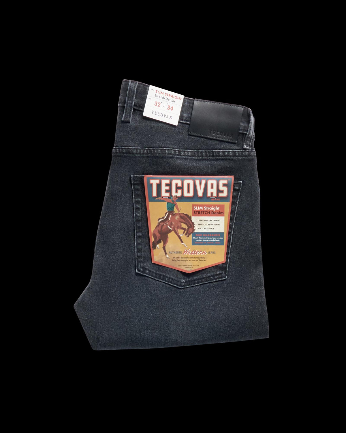 Folded pair of dark wash Tecovas jeans with a retail label featuring a rider on a horse, displayed on the back pocket.