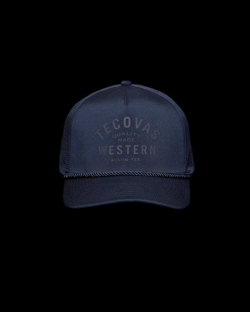 Navy blue trucker hat with mesh back, black rope detail above the brim, and "Tecovas Quality Made Western Austin, Tex." printed on the front.