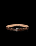 A brown leather belt with floral embossing, a silver buckle, and "Tecovas" branding on the inside. The belt is laid in a circular shape on a white background.