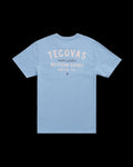 Light blue short-sleeve t-shirt with “Tecovas maker of fine Western Goods Austin, Tex” printed in white and beige text on the back.