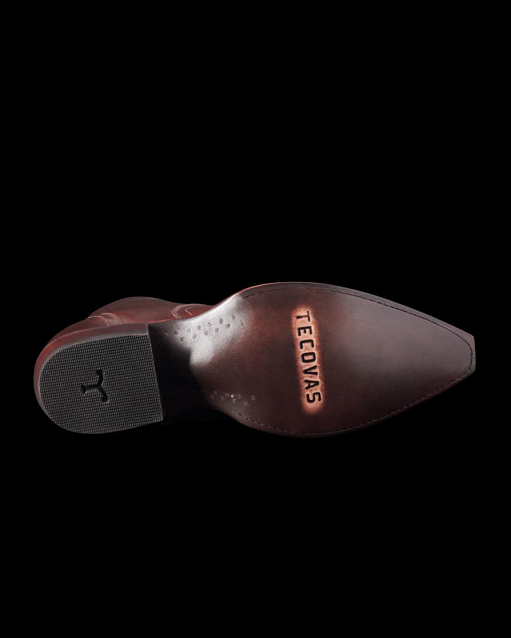 Brown leather cowboy boot sole with the brand name "Tecovas" embossed on it. The heel has a rubber grip insert and a subtle horse logo.