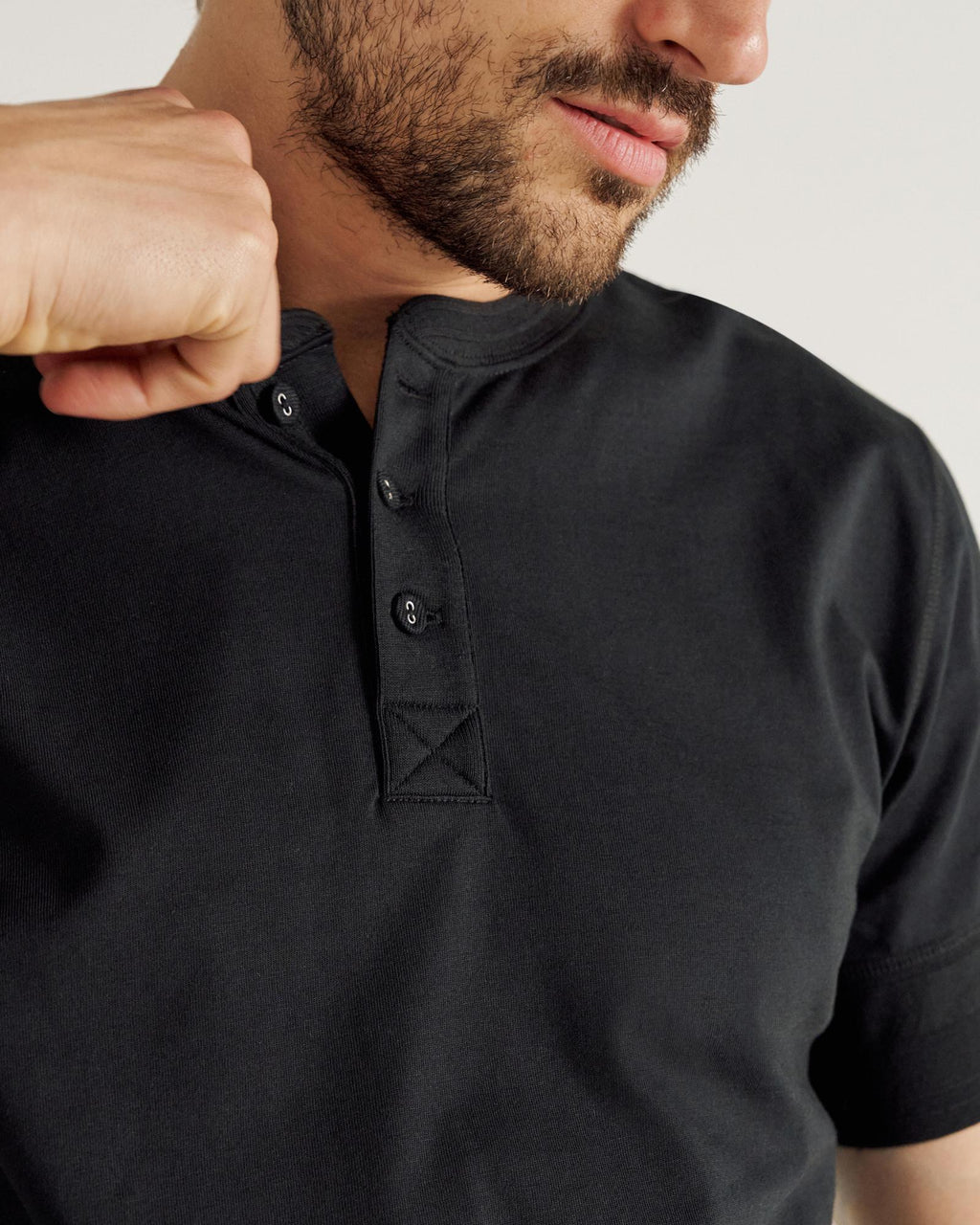 closeup of man wearing a black henley