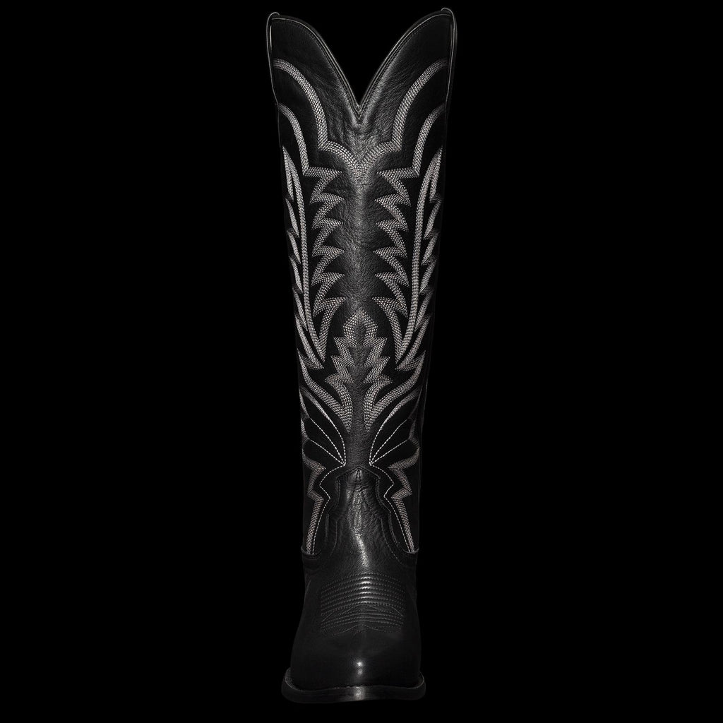 Tall black cowboy boot featuring intricate white stitching design on the shaft.