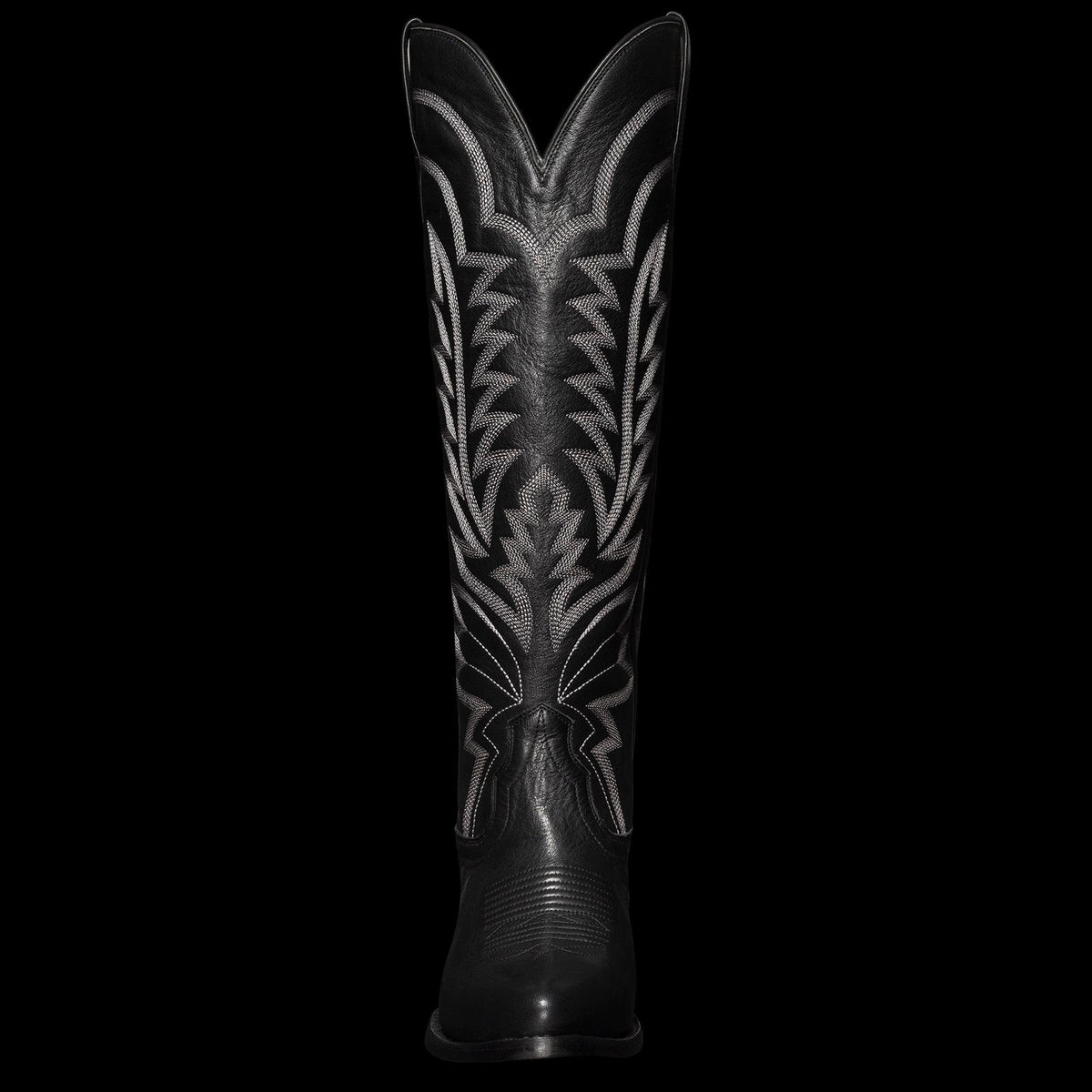 Tall black cowboy boot featuring intricate white stitching design on the shaft.