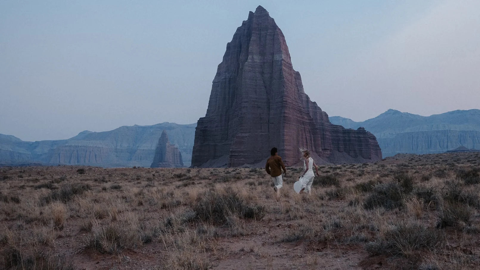 A couple walking through an open desert landscape