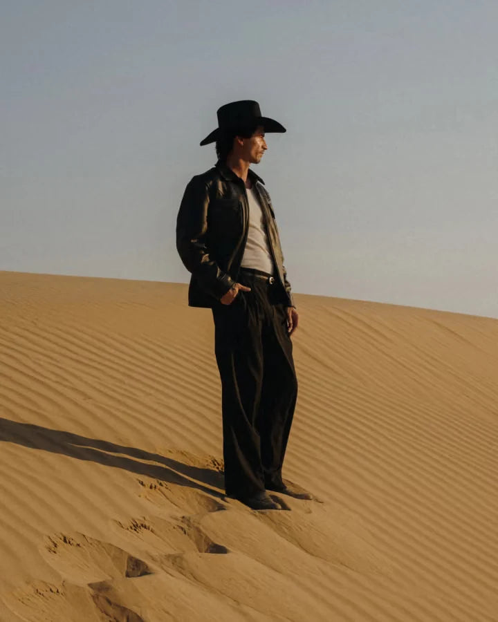 Western-inspired layered outfit in a sandy landscape